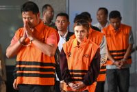 Kasubdit Pengelolaan Bantuan dan Kedaruratan BNPB sekaligus pejabat pembuat komitmen Gabriel Purwaka Sigit (kiri), Bima Setiawan (kanan) pihak swasta yang merupakan adik Kepala BNPB Letjen TNI Suharyanto, dan pihak swasta Syifa Nrika Ghifarian (kedua kiri) berjalan mengenakan rompi tahanan seusai menjalani pemeriksaan di Gedung Merah Putih KPK, Jakarta, Rabu (14/10/2026). KPK menahan lima tersangka, yakni pejabat pembuat komitmen BNPB Gabriel Purwaka Sigit, Bima Setiawan, Richard Erlangga, serta dua pihak swasta, Gery Prasetiawan dan Syifa Nrika Ghifarian, dalam kasus dugaan korupsi di lingkungan Badan Nasional Penanggulangan Bencana (BNPB) yang terungkap melalui Operasi Tangkap Tangan (OTT).