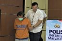 Polisi menggiring tersangka pembunuhan ibu dan anak di Kota Madiun berinisial DBM (40) di Mapolda Jatim, Surabaya